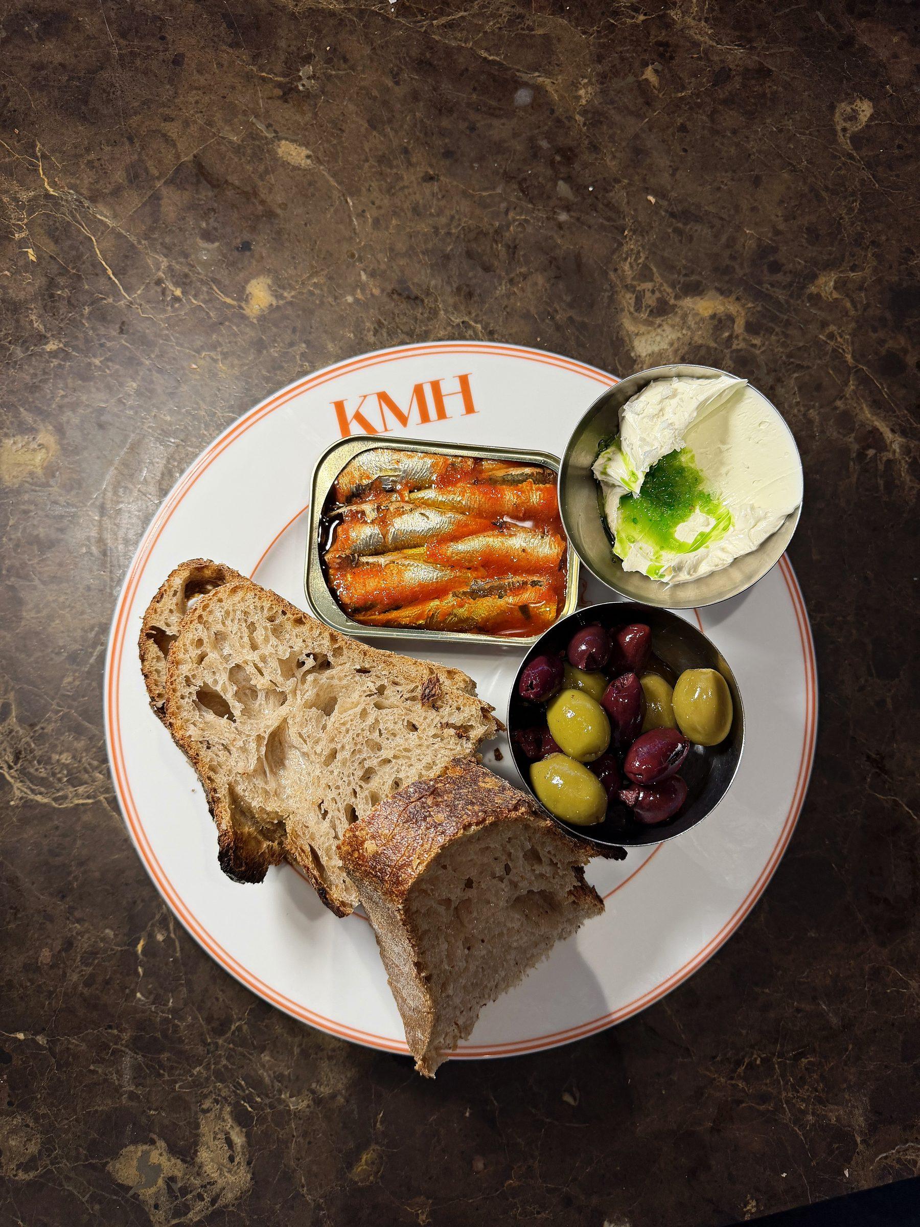 Sardinen, Brot und Oliven auf dem Marmortresen